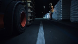 Sehen und gesehen werden - mit dem Fußgängerwarngurt von Linde Material Handling  Videoausschnitt, bei dem Stapler und Lagerarbeiter in dunklem Gang aufeinander treffen